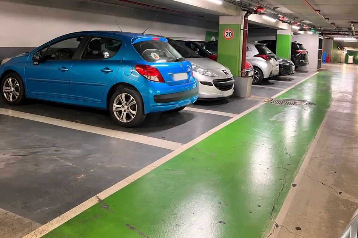 Le parking intérieur GoPark 60000 en sous-sol, avec des véhicules stationnés le long d’une allée